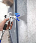 Top Tier Airless Spray Gun Compatible With Graco Paint Sprayers Featuring 517 Tip Nozzle Guard 3600 Psi Rating And Smooth As Butter Four Finger Trigger Ace Applicator spraying paint on a wall.