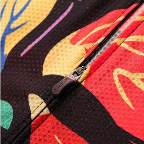 Close-up of colorful fabric with a black zipper, showing abstract patterns in red, yellow, and purple hues.