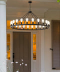 53 Inch Farmhouse Wagon Wheel Chandelier With 24 Lights Rustic Black Round Ceiling Light installed on porch