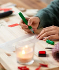 Person using 12 Inch Large Number Stencils Set With 0 To 9 Reusable PET Plastic Templates for crafting on a wooden table.