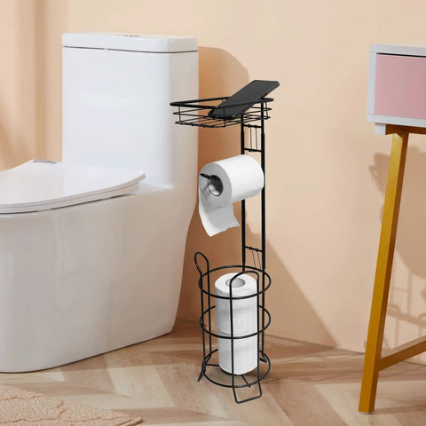 Freestanding movable toilet paper holder stand with raised base and top shelf holds three rolls plus phone or wipes space saver tissue dispenser for bathroom black finish next to toilet.