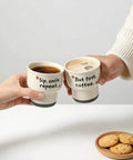 Two hands holding Ceramic Demitasse Espresso Cups Set Of 2, 3.52 Oz Handleless Demitasse Mugs for coffee with text, cookies on table.
