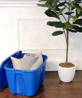 Open 4 Pack 18 Gallon Blue Plastic Storage Bin With Lid next to plant, showing pillows inside for bedroom, kitchen, and garage organization