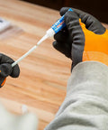 Klein Tools 56025 non-conductive fish tape repair kit, close-up view of gloved hands applying adhesive to fish tape.