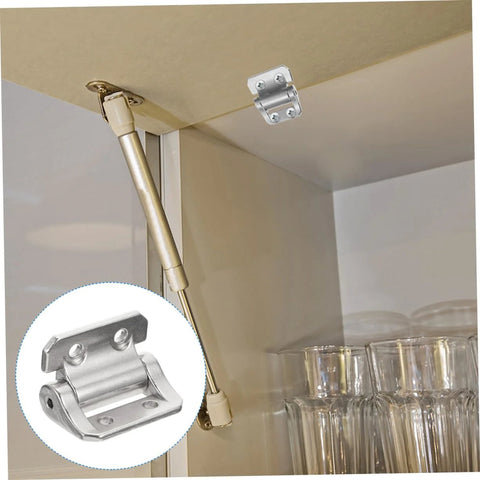 Silver cabinet door hinge with integrated damper for soft-close, mounted on a cabinet edge.