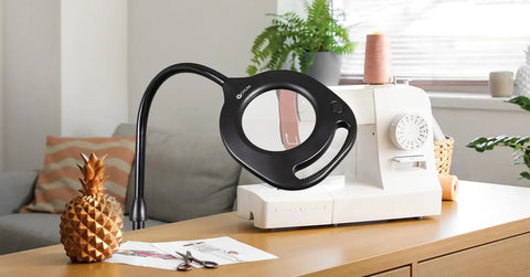 All In One Craft Lamp With Magnifier And LED Table Light Flexible Gooseneck Handy Desk Light next to sewing machine on desk