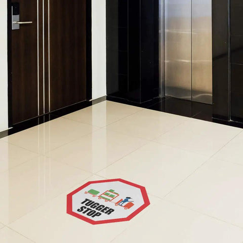 Stop That Tugger Now With These Heavy Duty Red Anti Slip Floor Decals Featuring Tough Round Vinyl Stickers For Warehouses And Factories To Boost Safety And Guide Forklifts Perfectly On Any Surface placed on a floor near an elevator.