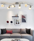 Six-Light Flexible Track Lighting Rail With Glass Shade LED Spot Ceiling Lights in modern living room, brushed steel finish.