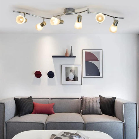 Six-Light Flexible Track Lighting Rail With Glass Shade LED Spot Ceiling Lights in modern living room, brushed steel finish.