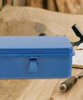 Classic Vintage Blue Metal Toolbox And Portable Tool Organizer For Auto Repair Job Site Storage Home Fix Ups Heavy Duty Rolling Gear Rack With Badass Grip Latches on a wooden surface.
