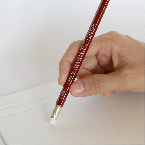 Hand using Mitsubishi Pencil With Eraser 9850 HB Hardness For School Or Office on notebook paper, smooth lead, red finish.