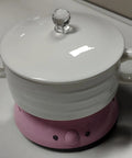 Top Shelf Electric Coffee Mug Warmer With Smart Temp Controls And Four Hour Auto Shutoff stays put on your desk with a pink base.