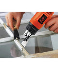 Person using a Corded Heat Gun For Crafts Or Diy Projects With Dual Temperature Settings Up To 1000 Degrees Fahrenheit And 1350 Watt Power Built In Stand For Easy Cooldown Ideal For Paint Stripping Rust Removal Pipe Thawing on window.