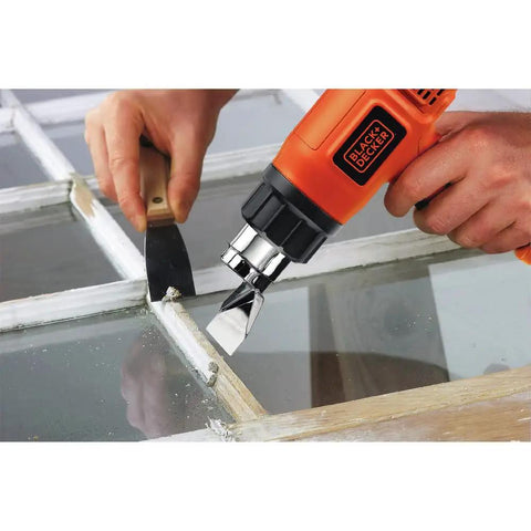 Person using a Corded Heat Gun For Crafts Or Diy Projects With Dual Temperature Settings Up To 1000 Degrees Fahrenheit And 1350 Watt Power Built In Stand For Easy Cooldown Ideal For Paint Stripping Rust Removal Pipe Thawing on window.
