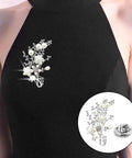 50 Piece Bulk Haul Of Top Shelf Metal Pin Backs Featuring Grip Tight Locking Clasps Perfect For Custom Lapel Pins And Enamel Badges. Decorative floral design with pearls, attached to a black garment.