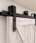 Heavy Duty Bypass Sliding Barn Door Hardware Kit For Low Ceiling Spaces, 12 Foot Double Track System Fits 72 Inch Wide Double Wooden Doors, J Shape Hangers, Steel Rails, Nylon Rollers, Anti Rust Design, Supports Up To 220 Lbs Inside Door. Close-up view of steel rail installation on wooden barn door.