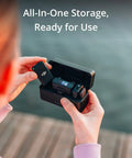 Person holding Wireless Lavalier Microphone System with two transmitters and one receiver in charging case, outdoor setting