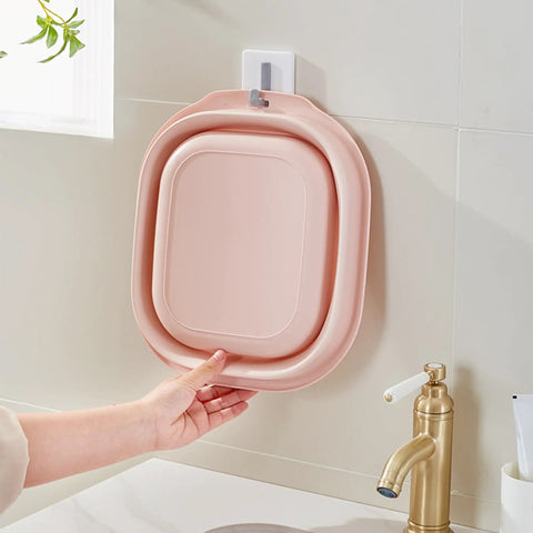 Collapsible Pink Wash Basin Set Of 2 Foldable Portable Laundry Basins hanging on wall in bathroom space saving design