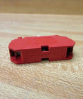 Straight Up Heavy Duty 10 Amp 22 Mm 600 Vac Contact Block Featuring Normally Closed Contacts And Vibrant Red Housing side view on wood background