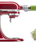 Red stand mixer with 7 Blade Spiralizer Plus With Peel Core And Slice Attachment for zucchini spirals into a clear bowl.