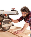 Man using Heavy Duty Radial Arm Saw Laser Guide for precision cuts with a visible laser line, working on wood in workshop.