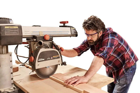 Man using Heavy Duty Radial Arm Saw Laser Guide for precision cuts with a visible laser line, working on wood in workshop.