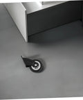 Four Piece Heavy Duty Sliding Door Roller Wheels And Rock Solid Side Mount Casters For Barn Doors Cabinets And Furniture featuring a black roller wheel on a gray floor.