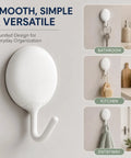 Heavy Duty Adhesive Wall Hooks For Bathroom And Kitchen No Drill Strong Sticky Hangers For Towels Coats Zero Hassle Residue Free 4 Pack solid white wall hook mounted in bathroom.