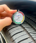 Pro Grade Dial Type Tire Tread Depth Gauge With 1/32 Inch Increments And 1/128 Inch Resolution placed on tire tread
