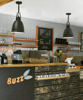 Cafe interior with black pendant lights similar to Hobson Glass Pendant Light In Satin Nickel, modern decor over counter area