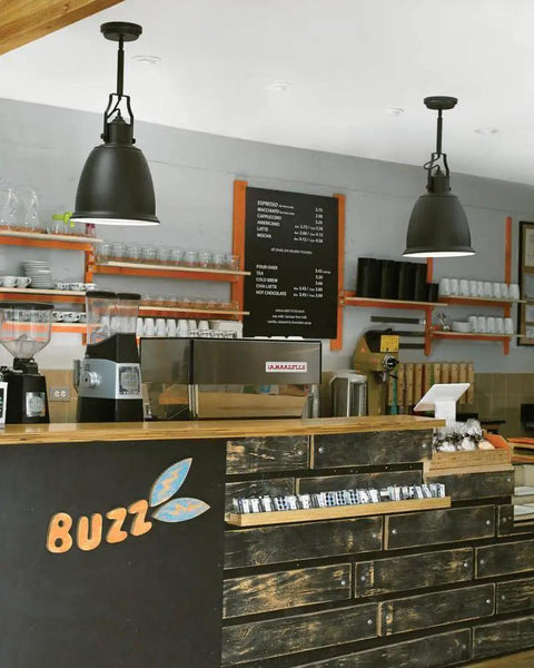 Cafe interior with black pendant lights similar to Hobson Glass Pendant Light In Satin Nickel, modern decor over counter area