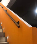 Rock Solid Wood Handrail With Heavy Duty Mount Brackets, Adjustable Non Slip Safety Grab Bar For Home Stairs, Hella Secure Support Rail For Seniors And Toddlers, No Sweat Wall Grip Setup on orange wall near stairs.