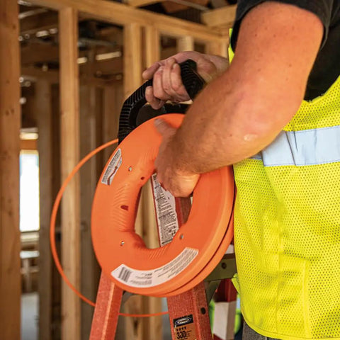 Worker using Non Conductive Electrical Fish Tape With Multi Groove Fiberglass Wire Puller Nylon Tip And Pro Grade Housing 100 Foot