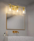 Gold Three Light Bathroom Vanity Light Fixture Over Mirror Vintage Style Wall Light With Easy Fifteen Minute Install Retro Farmhouse Vibe Gold Finish Compatible With LED Incandescent CFL And Halogen Durable Back Plate above a bathroom mirror