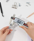 8 Inch Digital Caliper With Waterproof Stainless Steel Body measuring a small metal part with large LCD screen