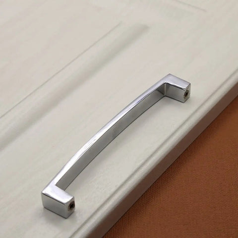 Crystal U Shaped Drawer Pull Handles In Bright Chrome With Screws installed on a cabinet door, minimalist design