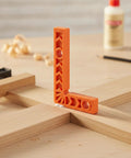 Dead Straight 90 Degree Woodworking Jig For Square Corner Assembly positioned on wood, showing its thick orange plastic design and use.