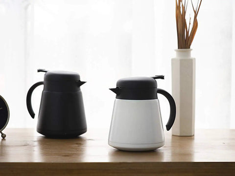 Black and white 68-ounce coffee carafes on table, Monster 68 Ounce Stainless Steel Vacuum Insulated Coffee Carafe With Double Wall Construction Press Button Top 12 Plus Hours Heat Retention And 24 Plus Hours Cold BPA Free Leak Proof For Coffee Tea Or Beverages Black
