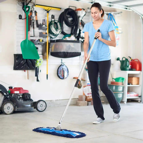 Woman using Badass Heavy Duty 24 Inch Nylon Dust Mop Head For Hardwood Floors in garage for cleaning.