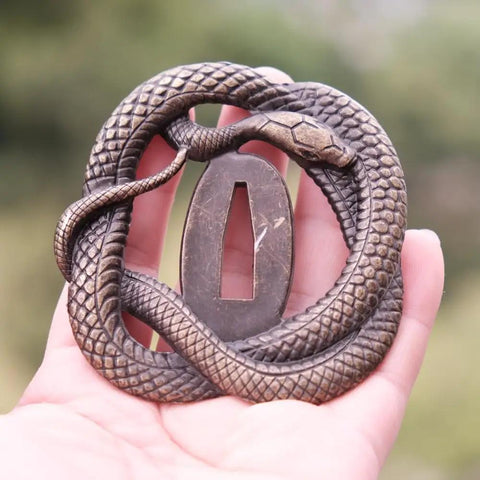 Koshirae Tsuba Fuchi Kashira Menuki Set for Samurai Swords with detailed snake design in alloy, shown in hand for size reference.