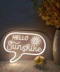 Sunshine Neon Sign For Wall Decor LED Light Up Sign For Bedroom Office Kids Room Nursery Living Room 12.2 By 9 Inches Warm White Glow Lit Vibe Great Perfect Birthday Gift For Girls And Boys showing 'Hello Sunshine' in warm white glow next to a vase with yellow flowers.