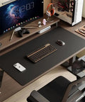 Two Sided Leather Desk Pad For Home Office Non Slip PU Leather Large Mouse Pad Waterproof Desk Mat 23.6x11.8 Inches Black Durable Surface For Work And Study Decor on a desk with computer and accessories.