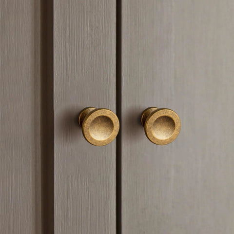12 Pack Antique Brass Round Cabinet Knobs With Single Hole on gray cabinet door, showcasing classic vintage hardware for furniture restoration