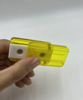 Hand holding a yellow fidget slider gadget for adults, compact PEI design for anxiety relief, smooth clicks aiding focus.