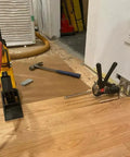 Viking Arm handheld jack/clamp with yellow base and black clamp, shown on wood floor near tools.