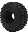 Close-up of a black textured off-road tire with deep treads, side view.