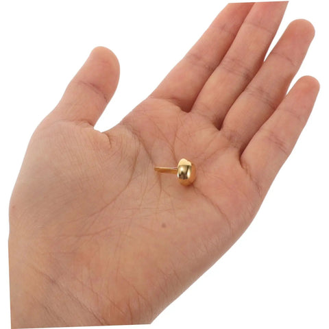 Versatile Craft Kit 100 Pcs Round Mushroom Brads And Mini Paper Fasteners in hand, showing golden metal brad fastener size and detail.