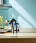 Fish Tank Water Hose Clip Holder Made Of ABS Plastic next to aquarium