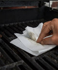 Hand wiping a grill with 350 Count White Heavy-Duty Shop Towels, Ultra Absorbent Industrial Wipers, Disposable Cleaning Cloths for Grill.