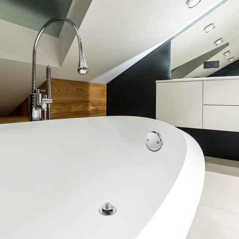 Top Notch Dual Hole Bathtub Drain Overflow Plate With Slick Chrome Finish and Included Matching Screws seen on white bathtub.